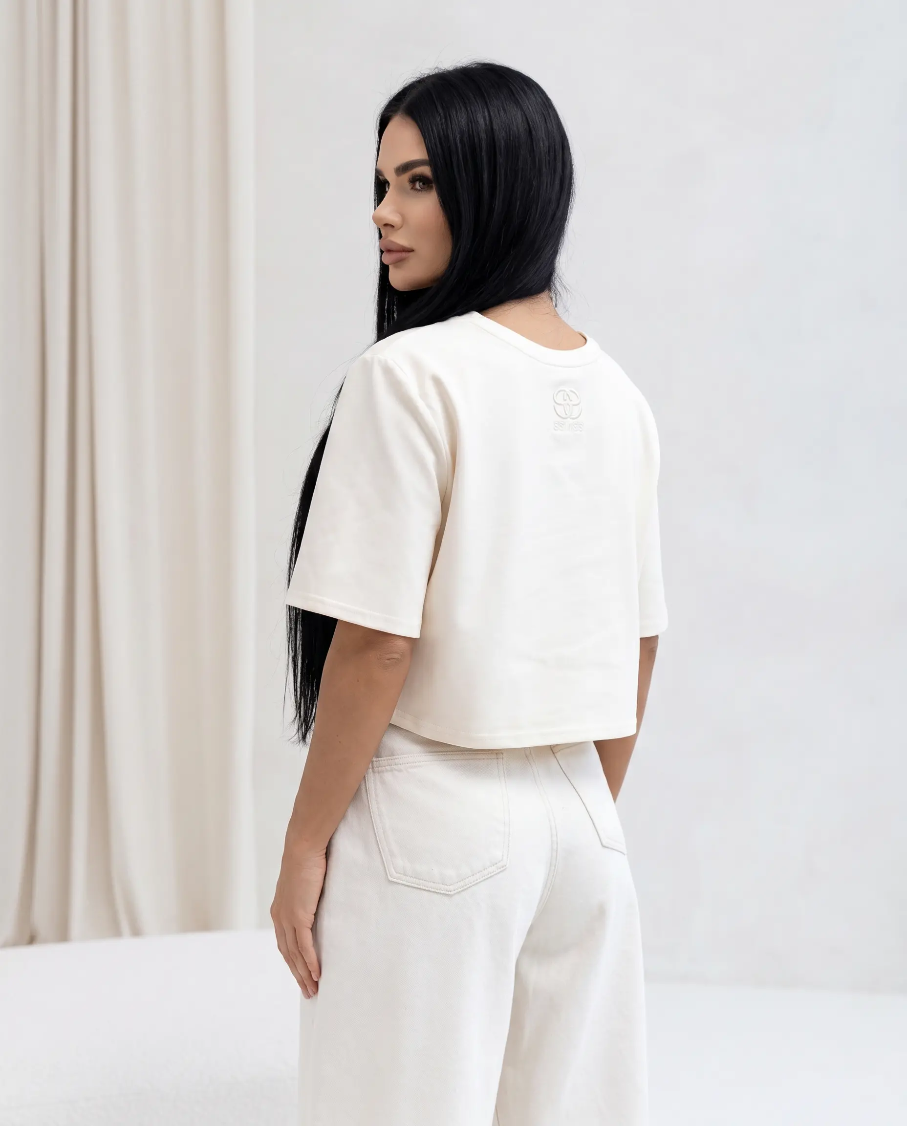 Waniliowy bawełniany t-shirt damski Arvia Cropped o luźnym kroju z subtelnym logo na plecach
